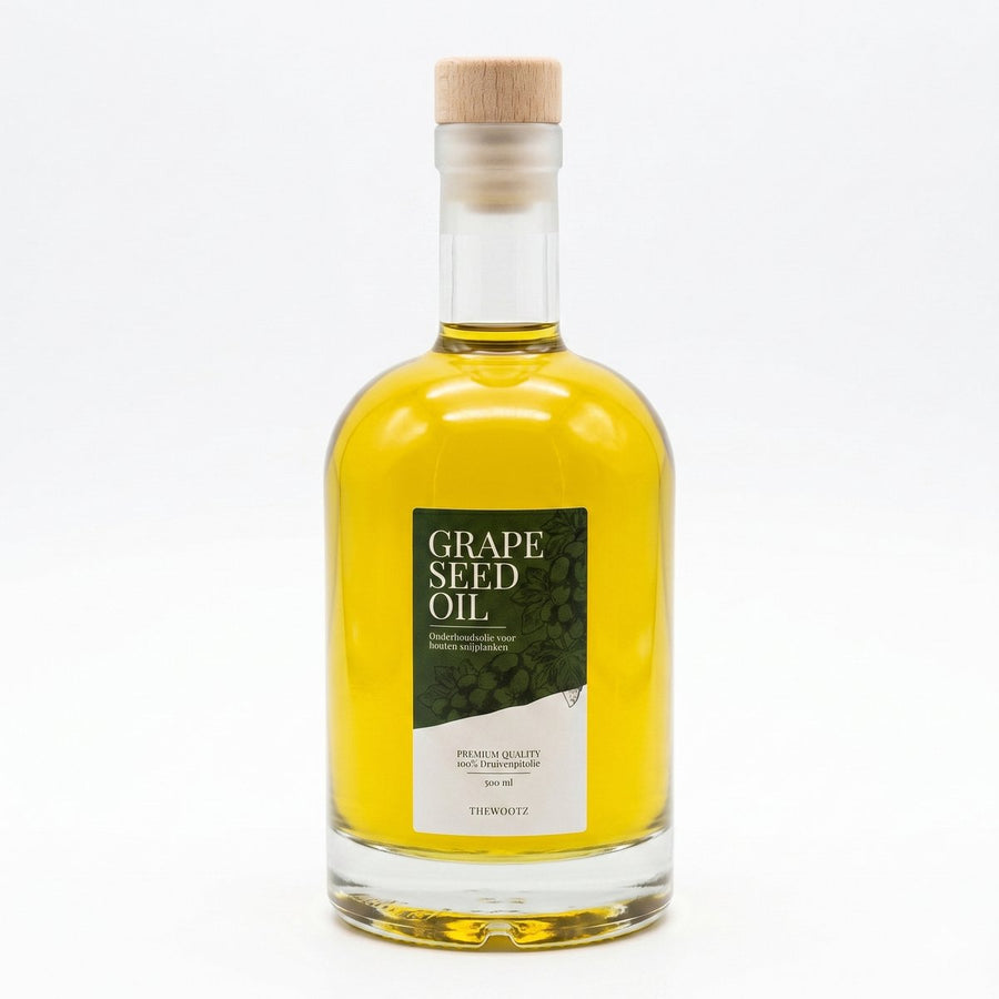 Fles met heldere druivenpitolie en een groen label met de tekst 'GRAPE SEED OIL' en 'THEWOOTZ'.