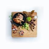 Gerecht met confit en kastanjepuree op een beukenhouten hakblok