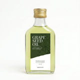Fles druivenpitolie van 200 ml met een goudkleurige dop en een groen-wit etiket met botanische illustratie.