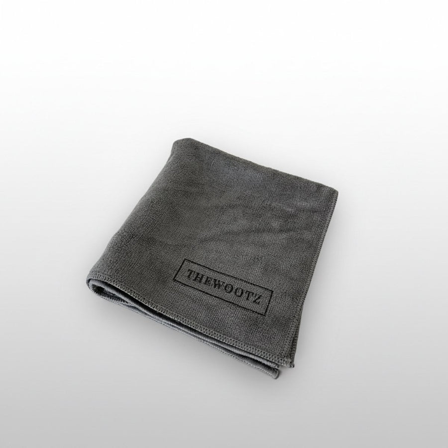 Grijs microvezeldoek met THEWOOTZ-logo.